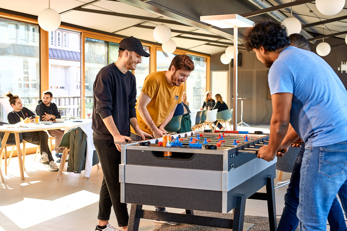 Office scene with a group of young men playing table soccer